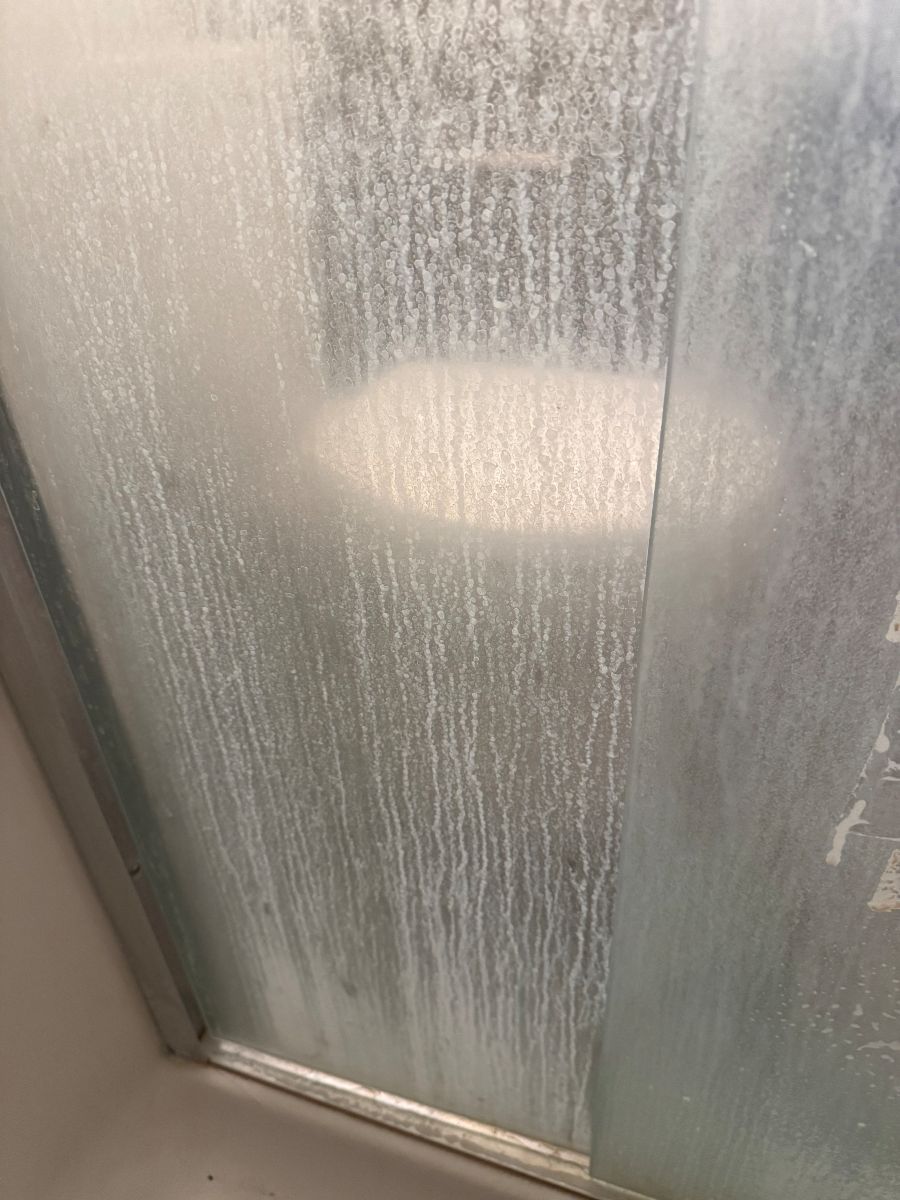 Glass shower door before cleaning